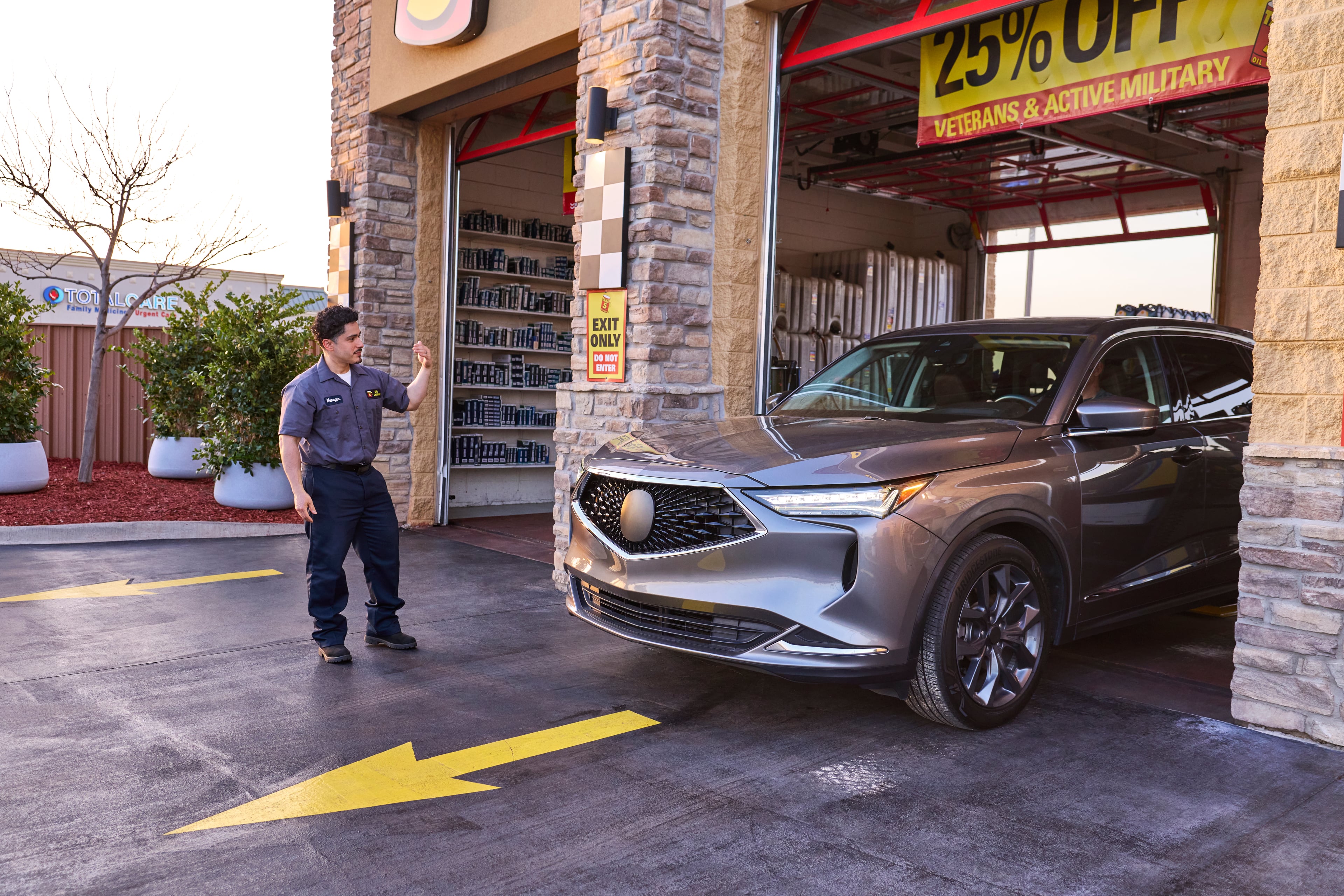 A Take 5 technician directs a driver out of the service bay.