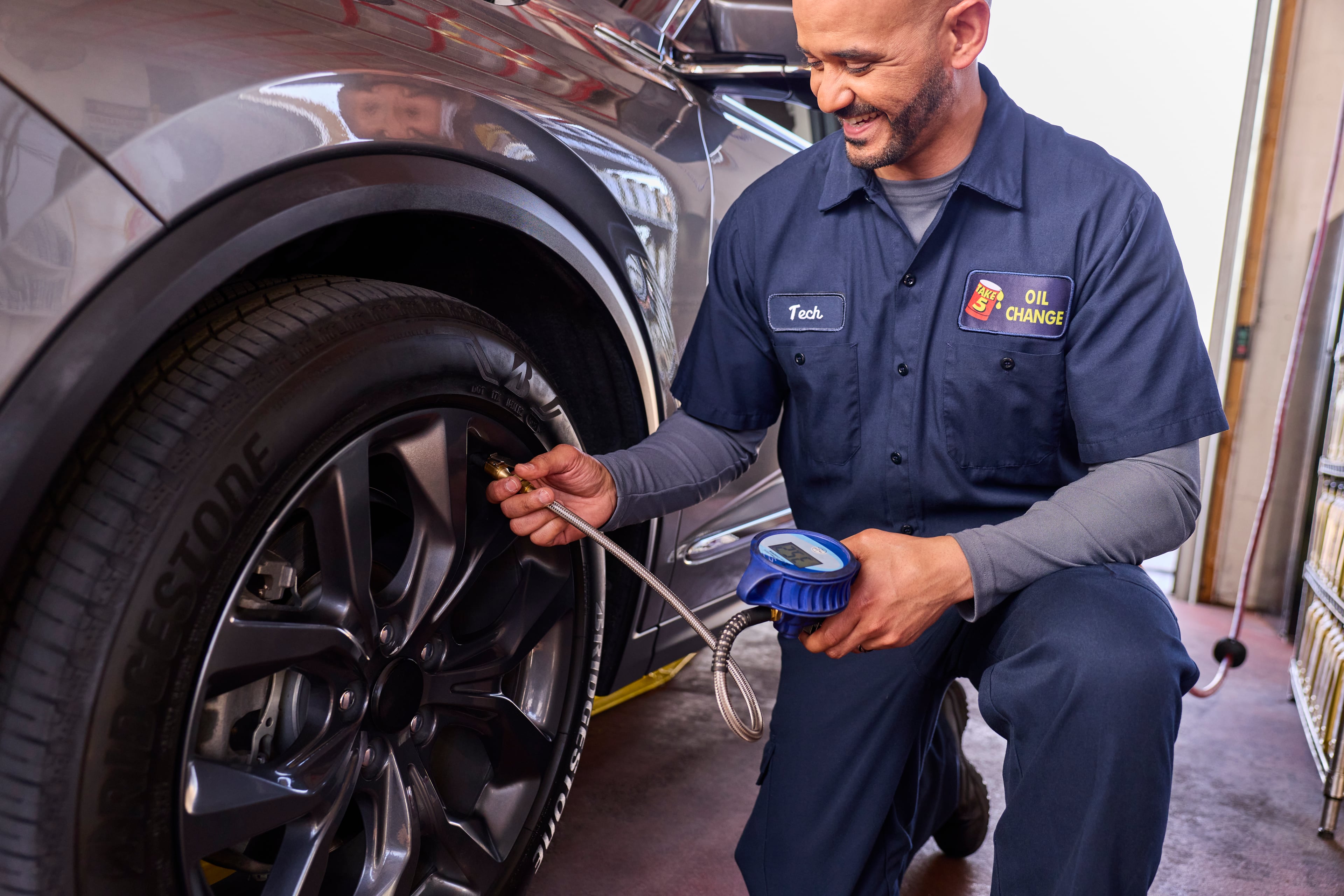 A Take 5 technician checks tire pressure during an oil change.