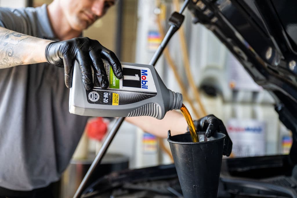 Take 5 technician pouring oil.