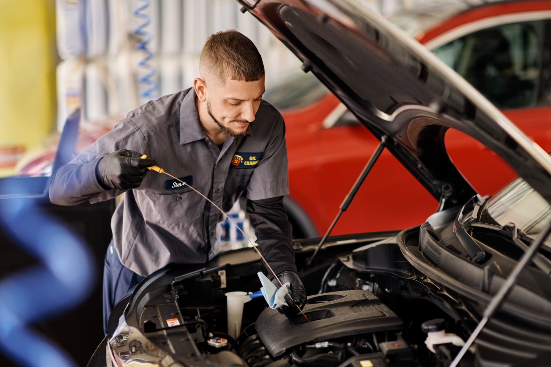 Technician checking oil at a Take 5 Oil Change